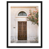Mediterranean brown wooden door and pink flowers
