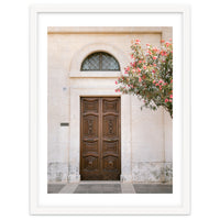 Mediterranean brown wooden door and pink flowers