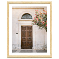 Mediterranean brown wooden door and pink flowers